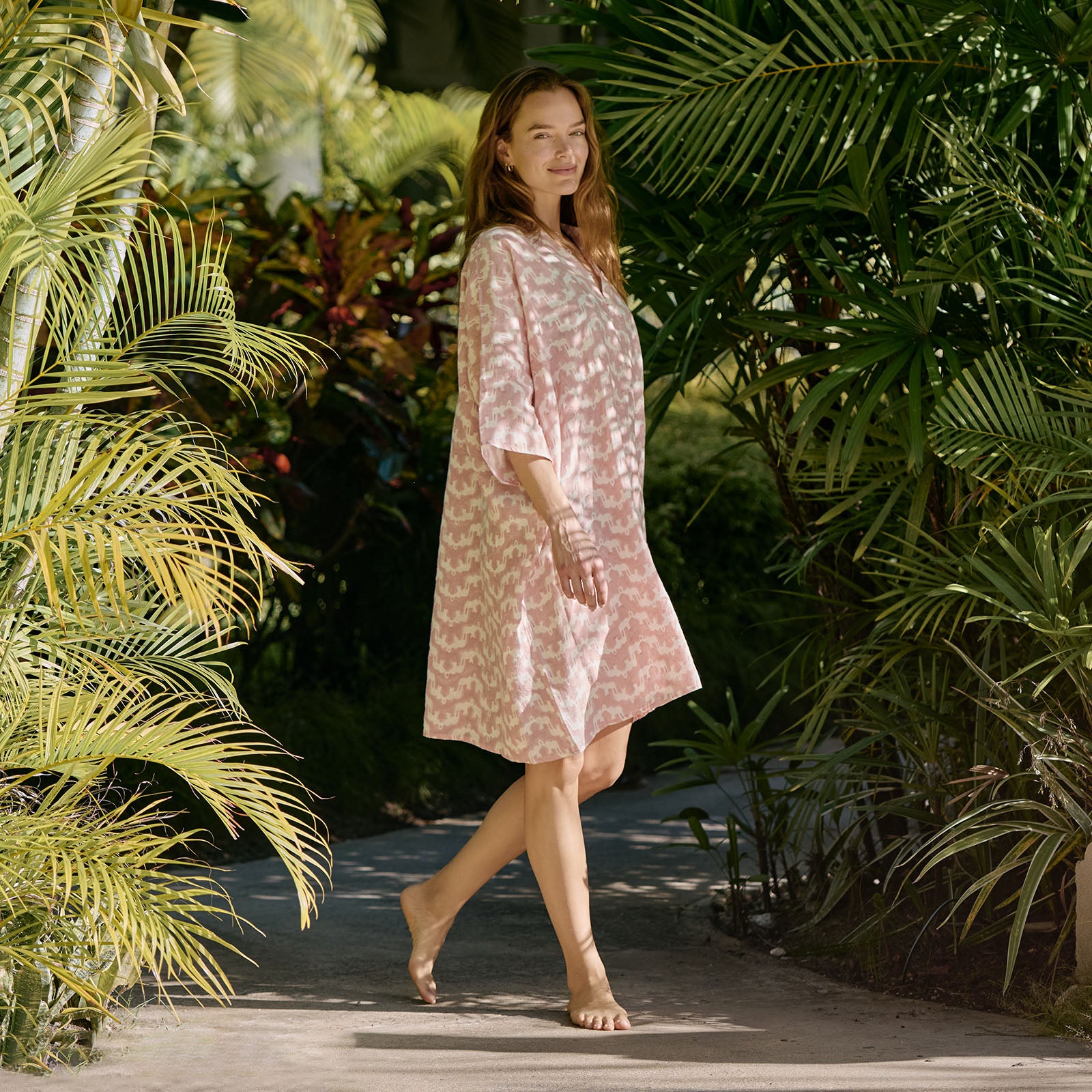 woman wears pink beach poncho