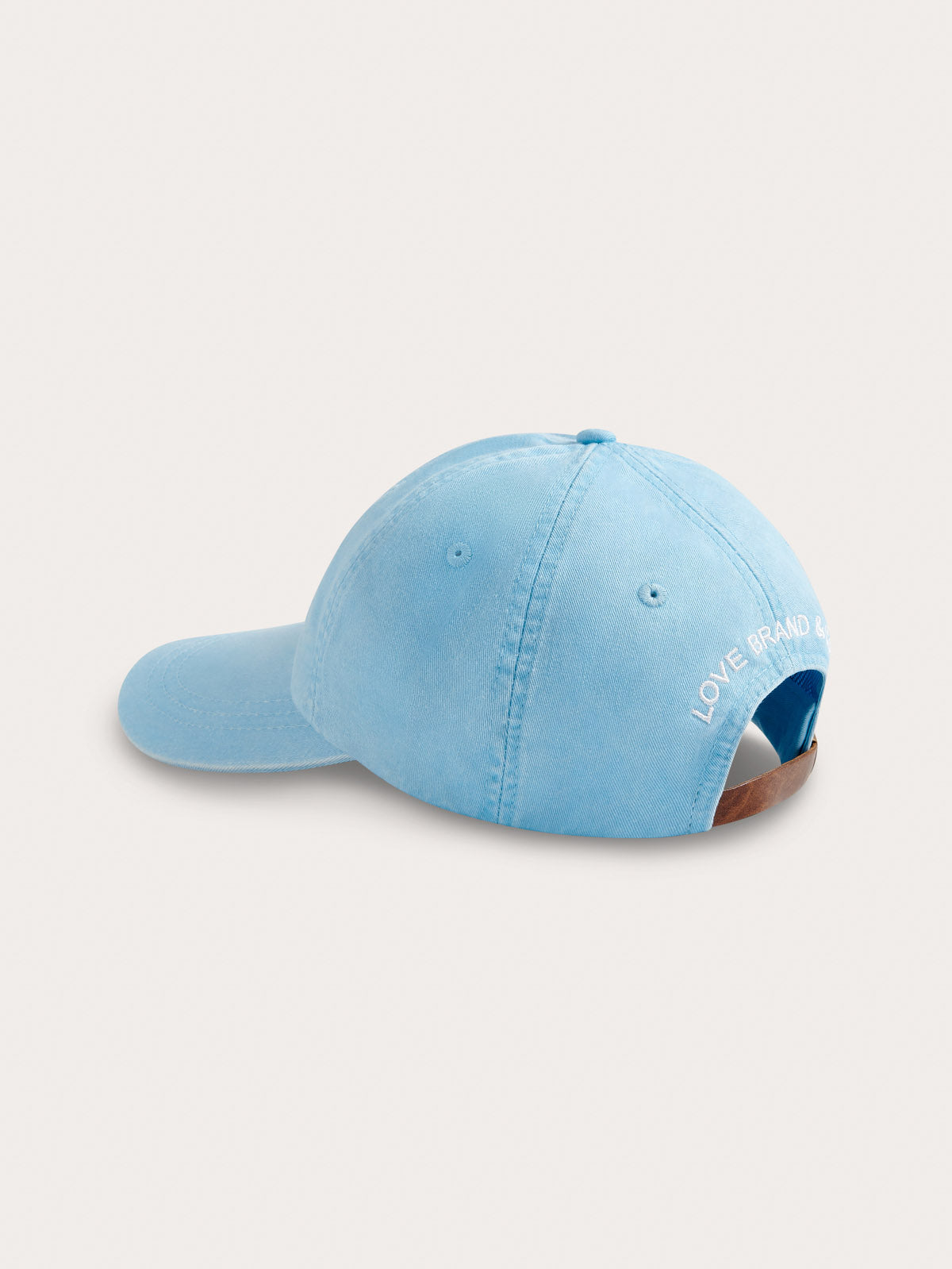 Light blue baseball cap with text on a light grey background