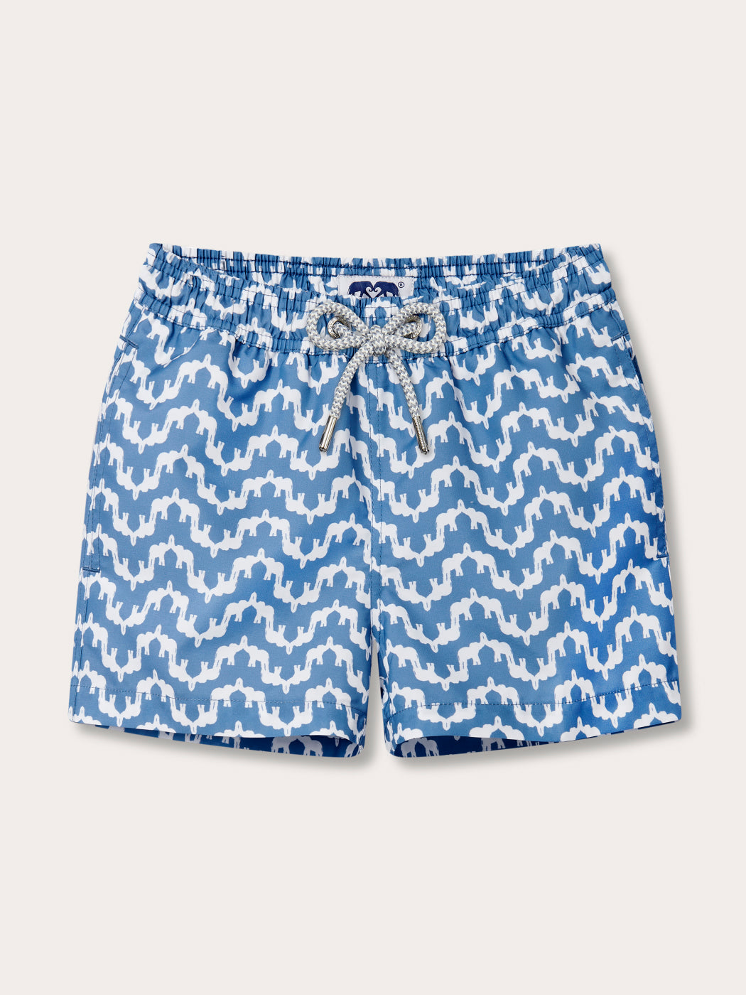 Blue and white patterned swim trunks with a white drawstring, shown flat on a light beige background.