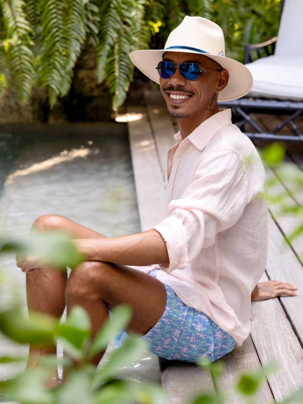 man wears linen shirt and blue swim shorts from mens beach wear brand love brand & co.