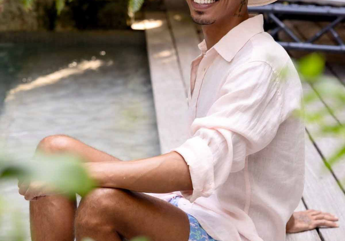 man wears linen shirt and blue swim shorts from mens beach wear brand love brand & co.