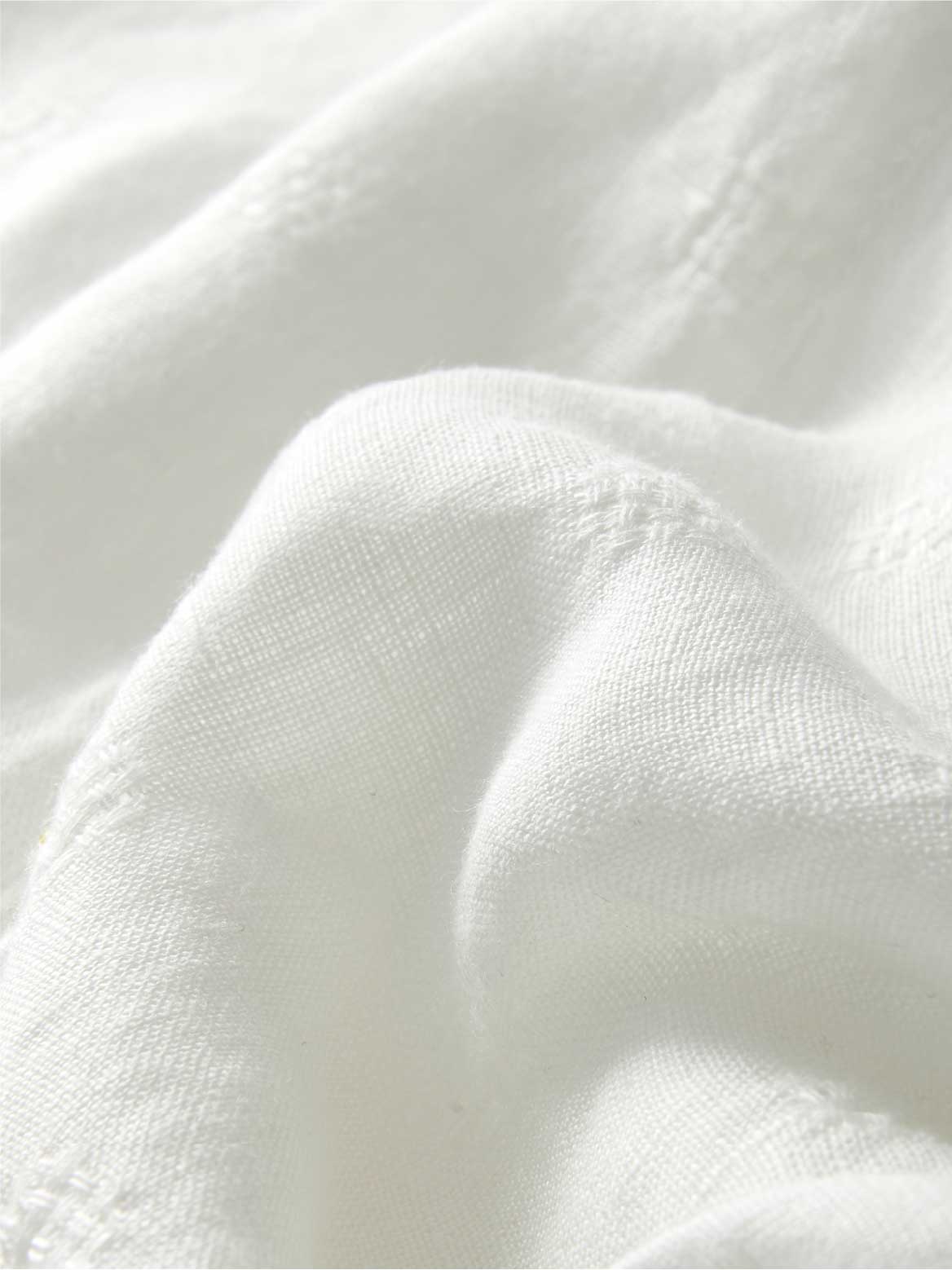 Close-up of cream linen fabric with folds.