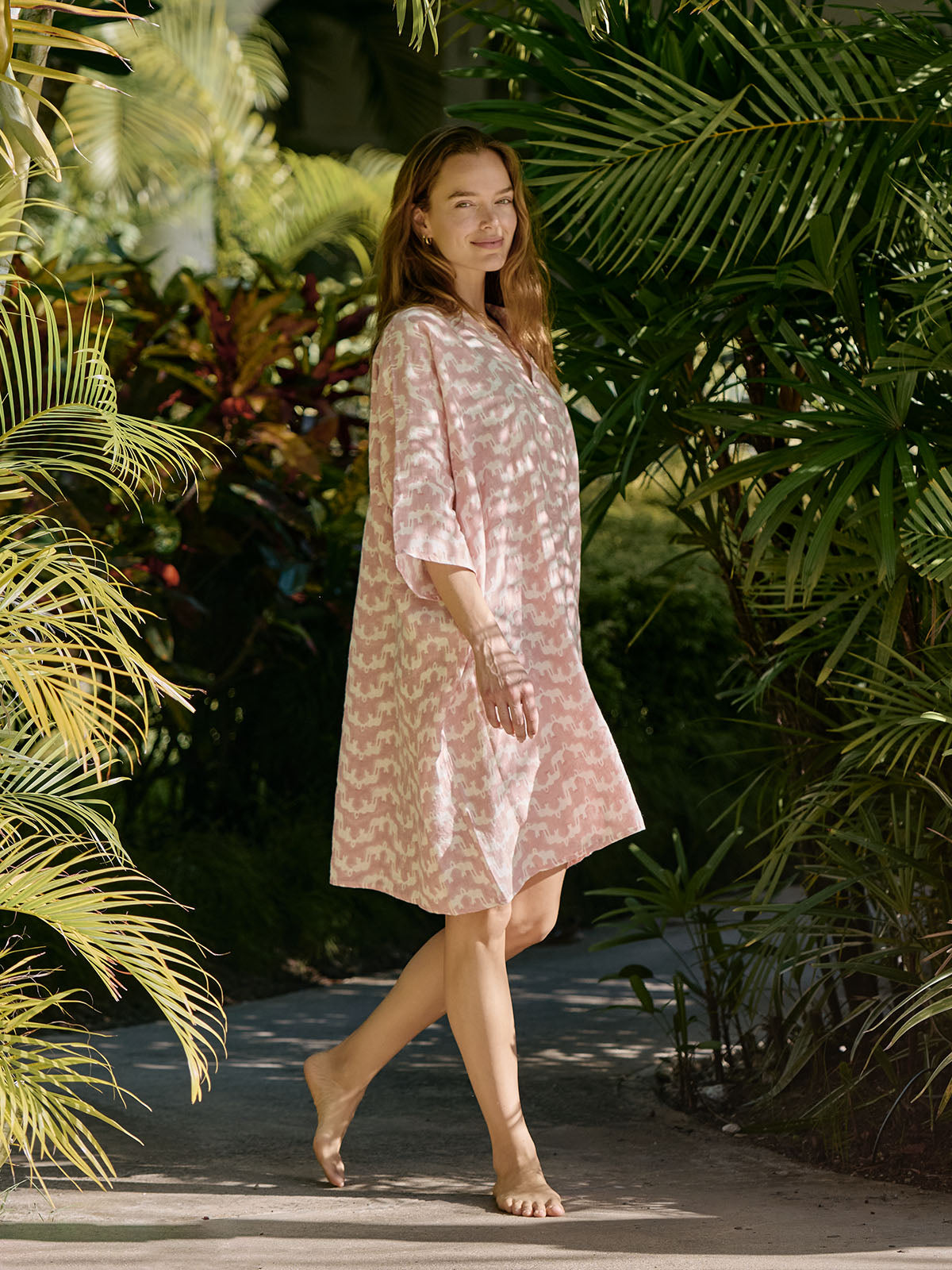 woman wears pink linen poncho