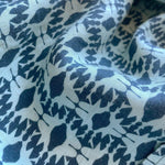 Close-up of Boys Shark Sanctuary Abaco Linen Shirt fabric featuring a pattern of swimming shark silhouettes creating an illusion of shark jaws, in shades of blue.