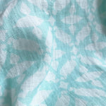 Close-up of Men's Dolphin Delirium Abaco Linen Shirt fabric with white and light blue dolphin print pattern.