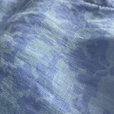 Close-up image of the blue elephant print on the Men's Elephant Dance Blue Abaco Linen Shirt, crafted from 100% premium linen. The fabric features a serene pale blue hue with an intricate elephant pattern.