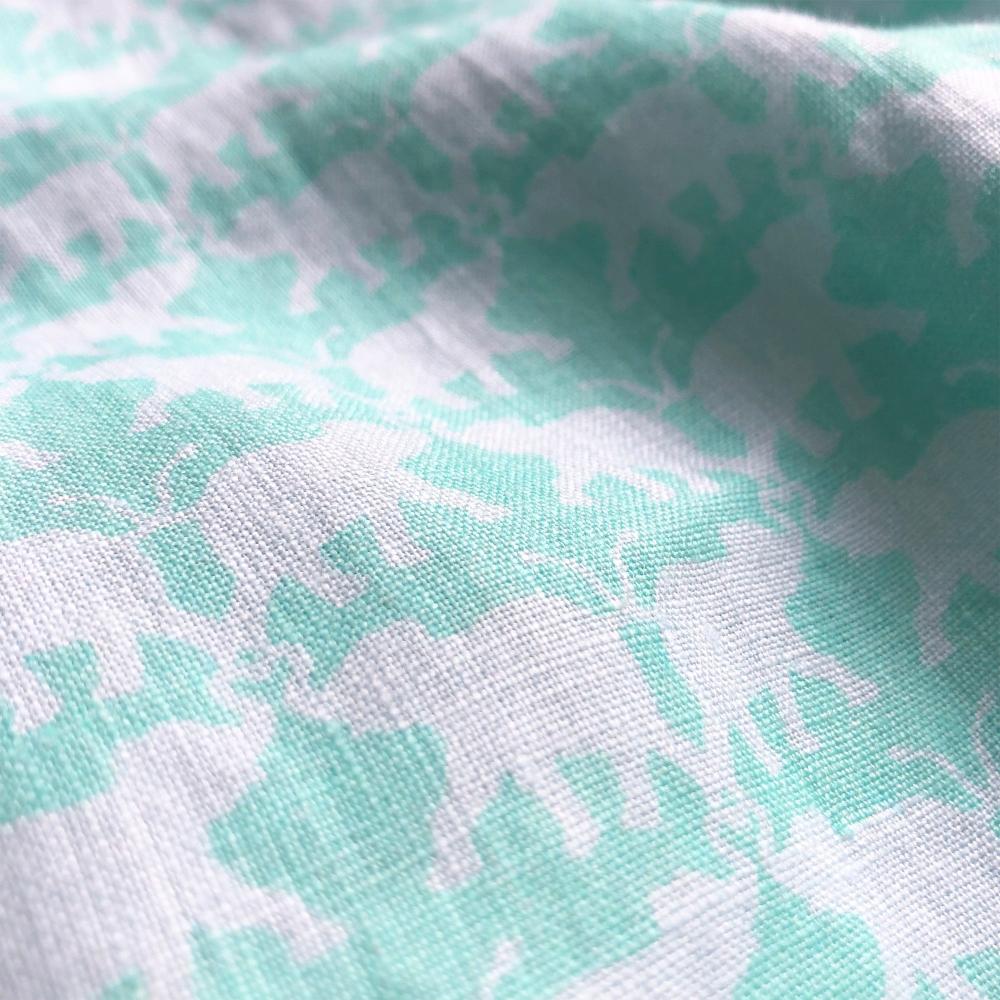 Elephant Dance Mint Abaco mens Linen Shirt fabric with white elephant print pattern on a mint green background.