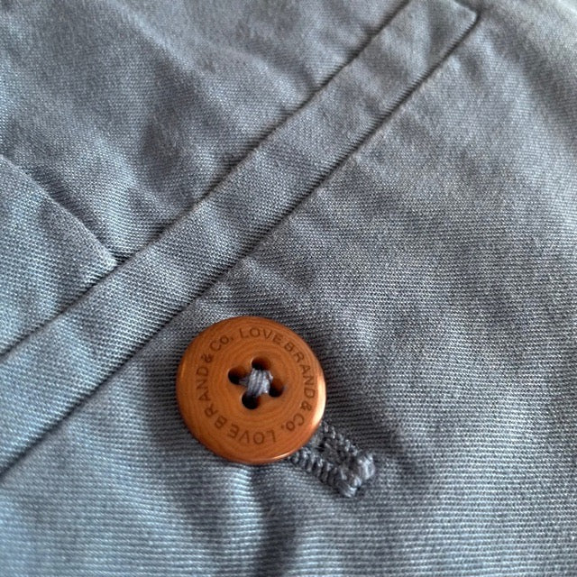 Close-up view of the corozo nut button on Men's French Blue Harvey Cotton Shorts made from soft-touch organic cotton twill.