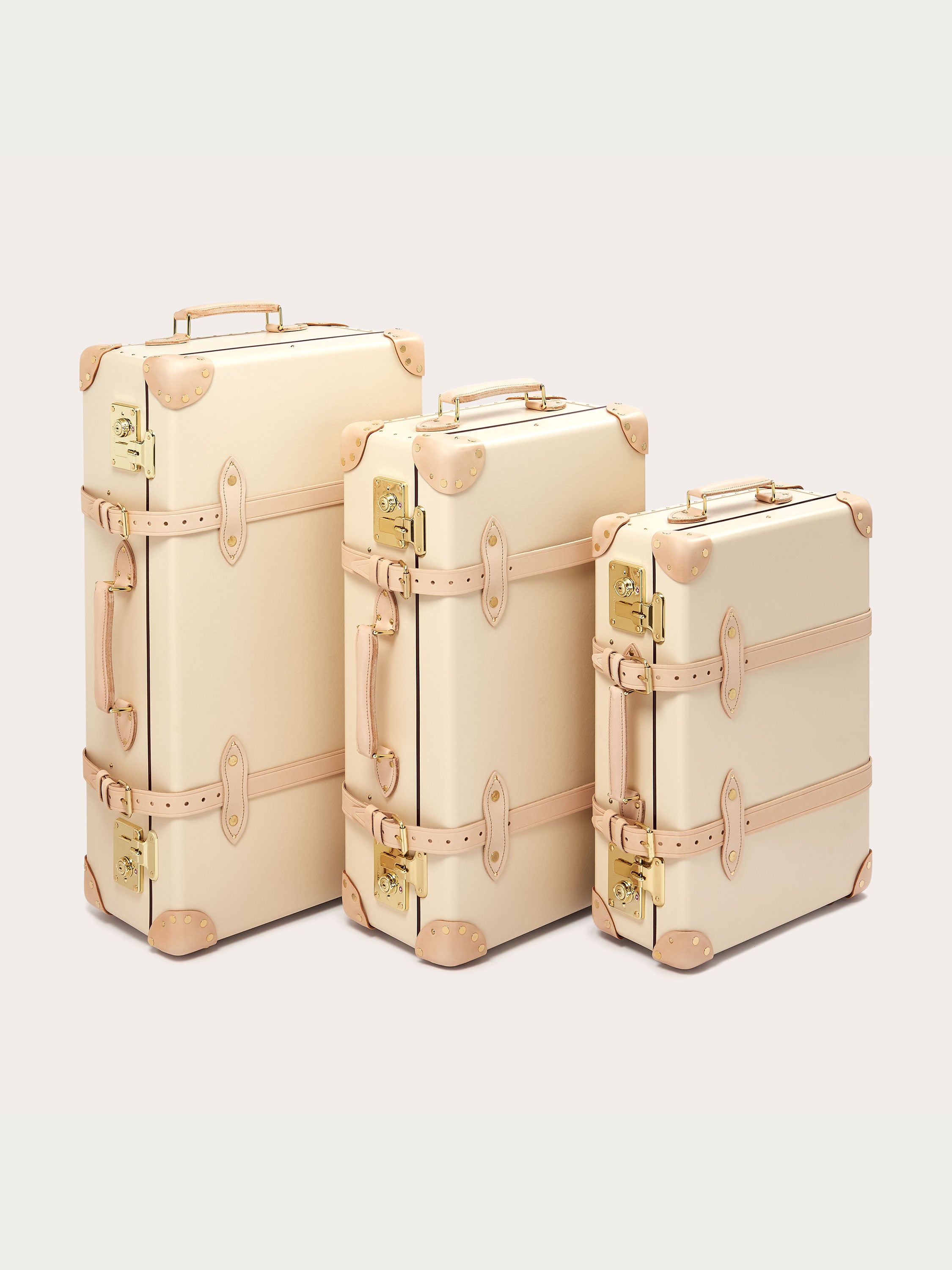 Three Globe-Trotter Safari 20" Trolley Cases in differing sizes, featuring vintage design elements and beige leather accents. All trolley cases are part of a limited edition collection by LOVE BRAND & Co., showcasing their signature 'Elephant Palace' print.