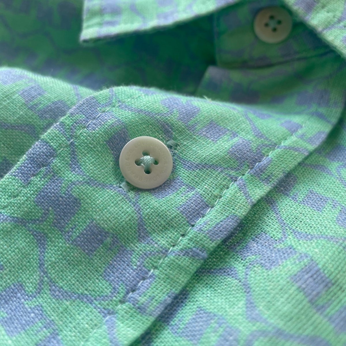 Green Bahamas Cay 100% linen shirt with lazy manatee prints and close-up of buttons.