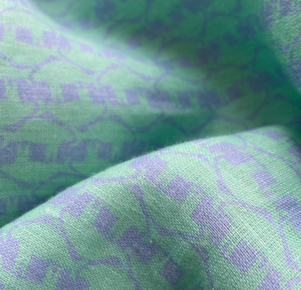 Close-up of the Bahamas Cay Green Men's Manatee Vanity Abaco Linen Shirt fabric showing a pattern with lazy manatees.