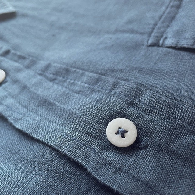 Close-up view of the Men's Midnight Blue Andros Hemp Shirt buttoned, showcasing the breathable and durable organic hemp fabric with pleated double chest pockets and corozo nut button details.