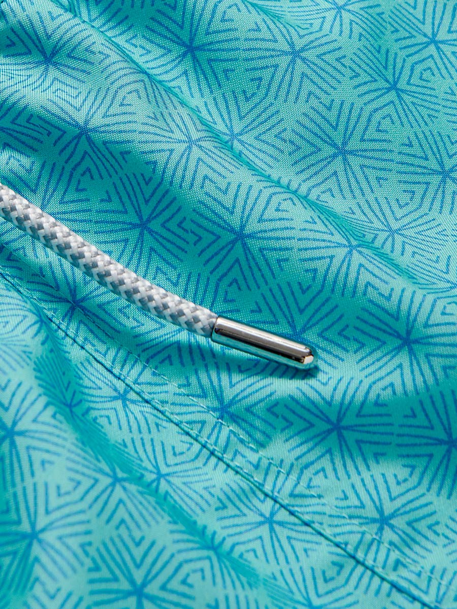 Close-up view of the Men's Sand Dollar Staniel Swim Shorts showcasing the intricate blue patterned fabric and white drawstring detail.