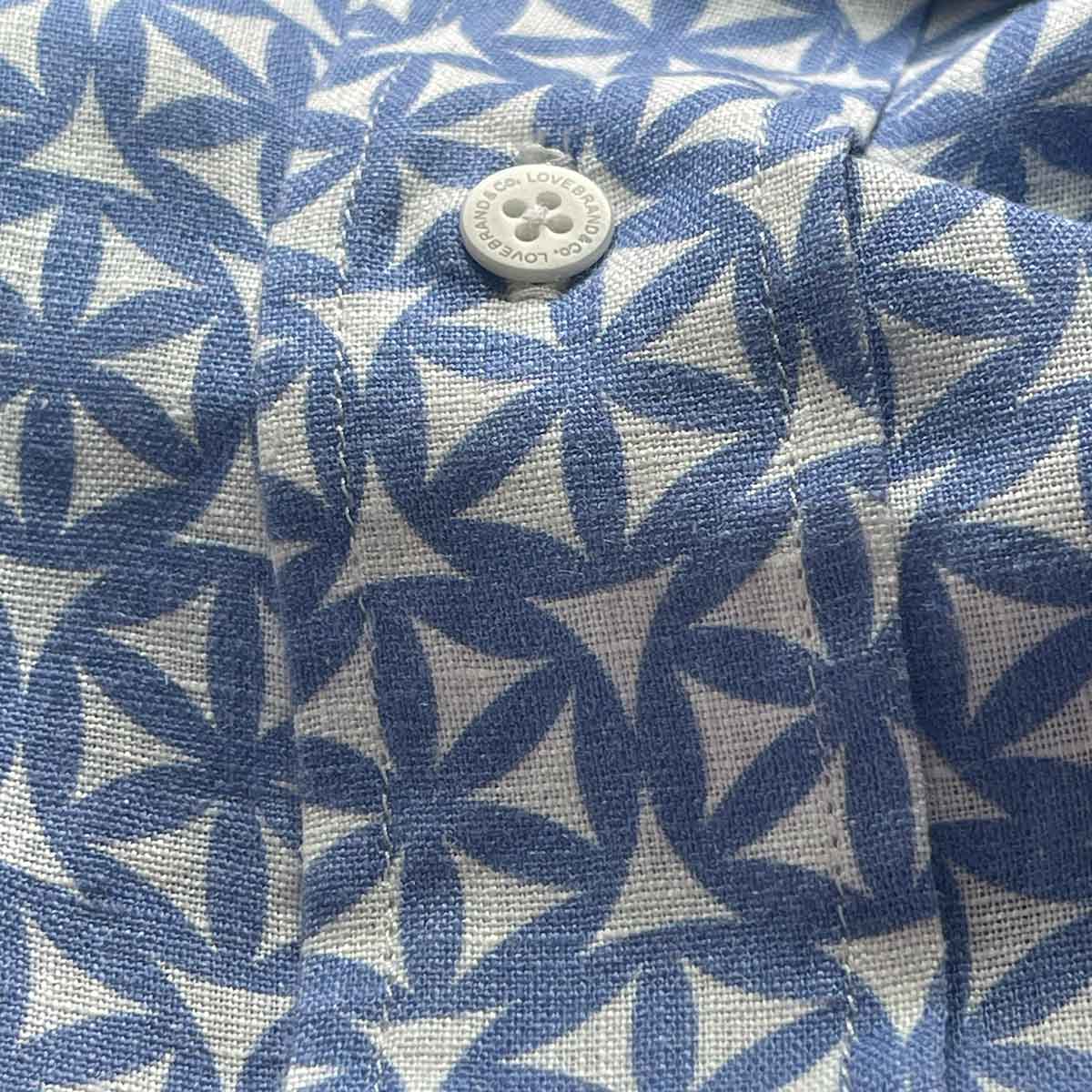 Close-up view of Men's The Best of the Best Abaco Linen Shirt from LOVE BRAND & Co., featuring an ocean blue rosette pattern with a six-leaf flower design.