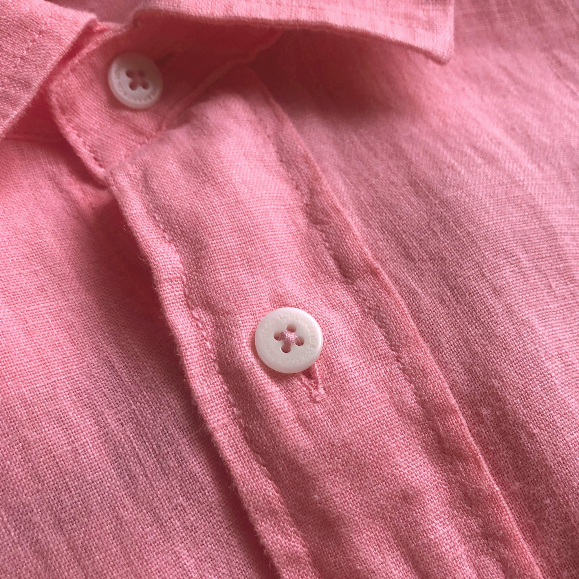 Close-up of the Men's Watermelon Abaco Linen Shirt with white buttons.