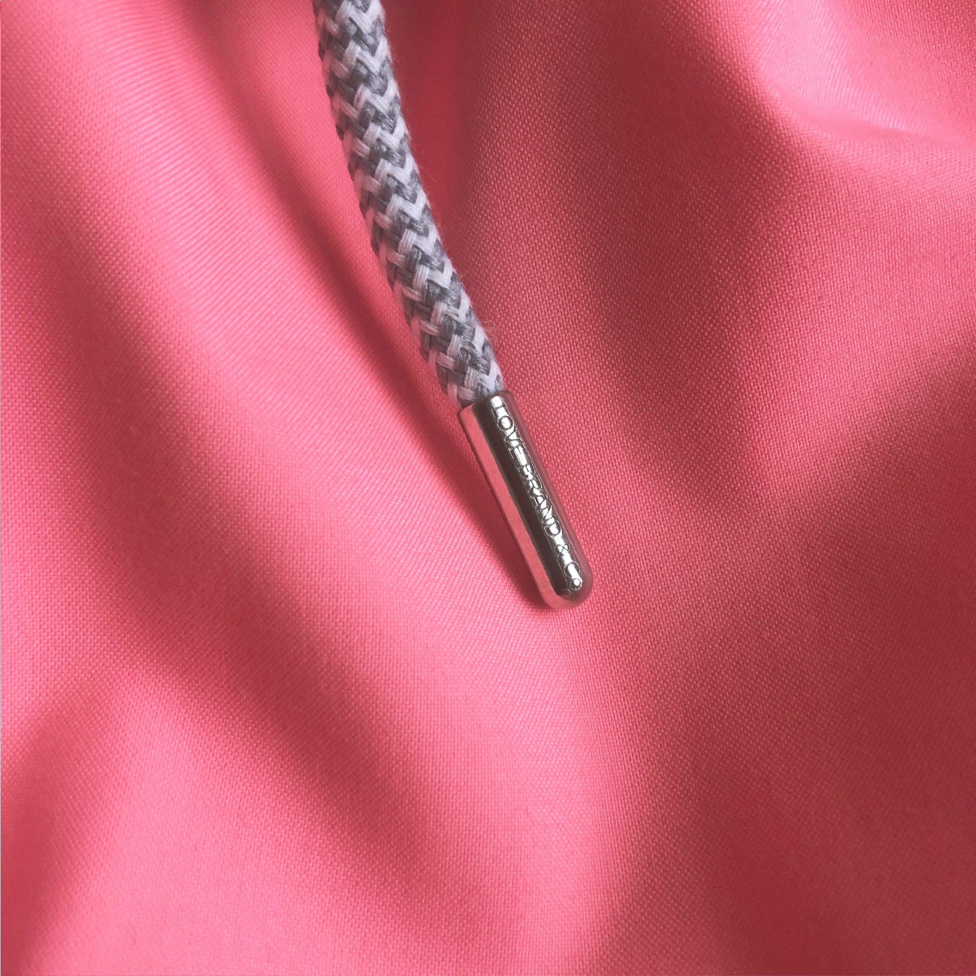Close-up of the Men's Watermelon Staniel Swim Shorts fabric and drawstring detail in bright pink-red.