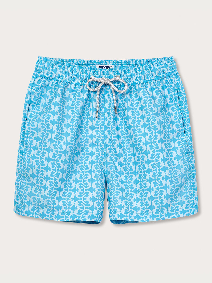 A pair of men's swim shorts with a tropical turquoise blue and white shark print design, featuring a drawstring waist and a brand tag on the left leg.