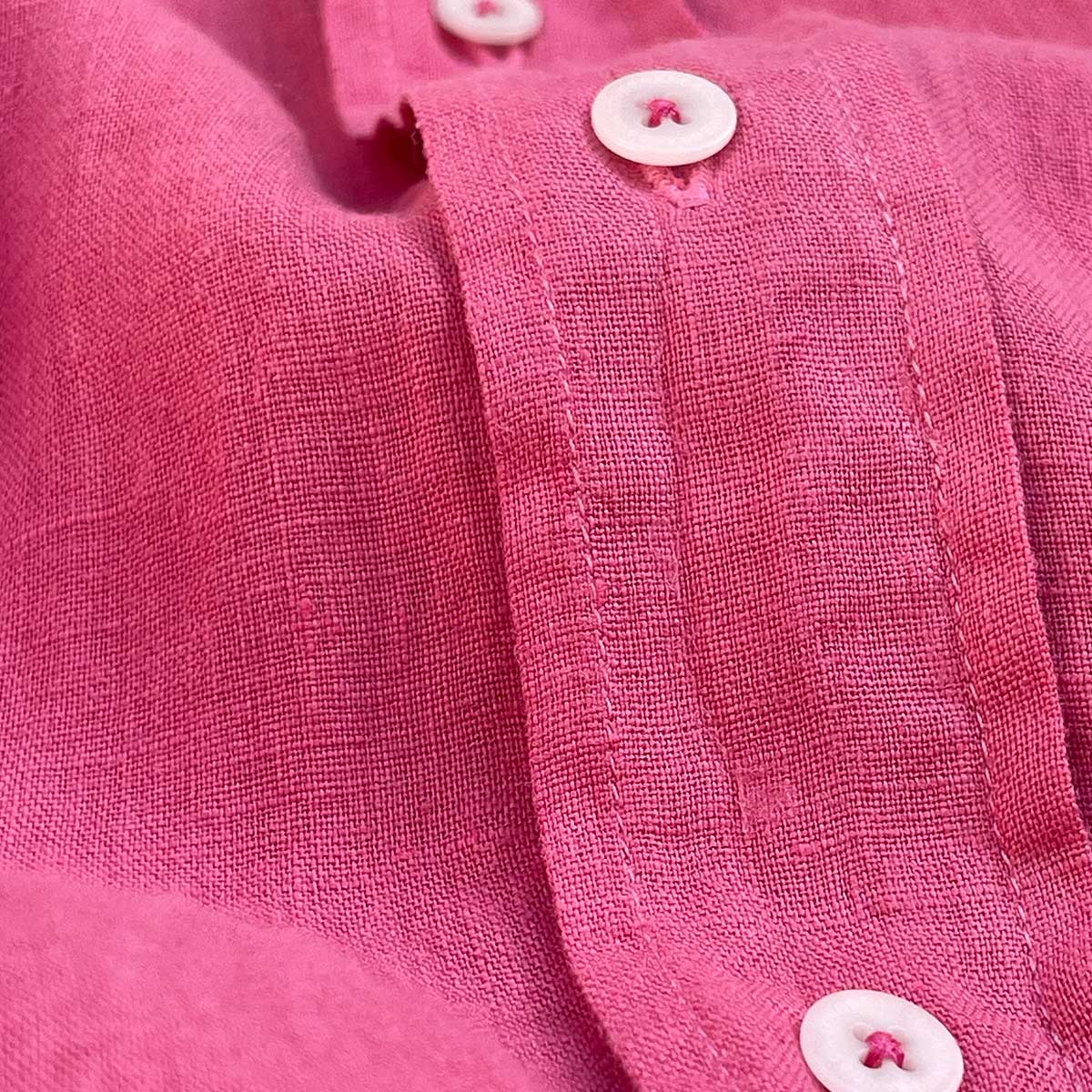 Close-up of Men's Ruby Red Abaco Linen Shirt fabric and buttons.