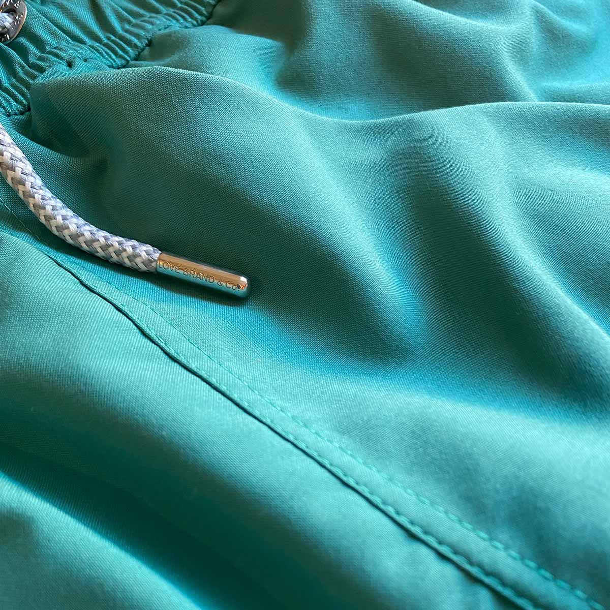 Close-up of Men's Palm Green Staniel Swim Shorts showing detailed stitching and drawstring.