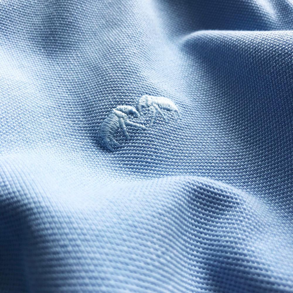 Men's Sky Blue Pensacola Polo Shirt fabric with embossed logo detail.