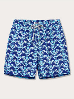 Men's blue and lavender turtle patterned swim shorts with an elastic waistband and drawstring, featuring signature branding on the back.